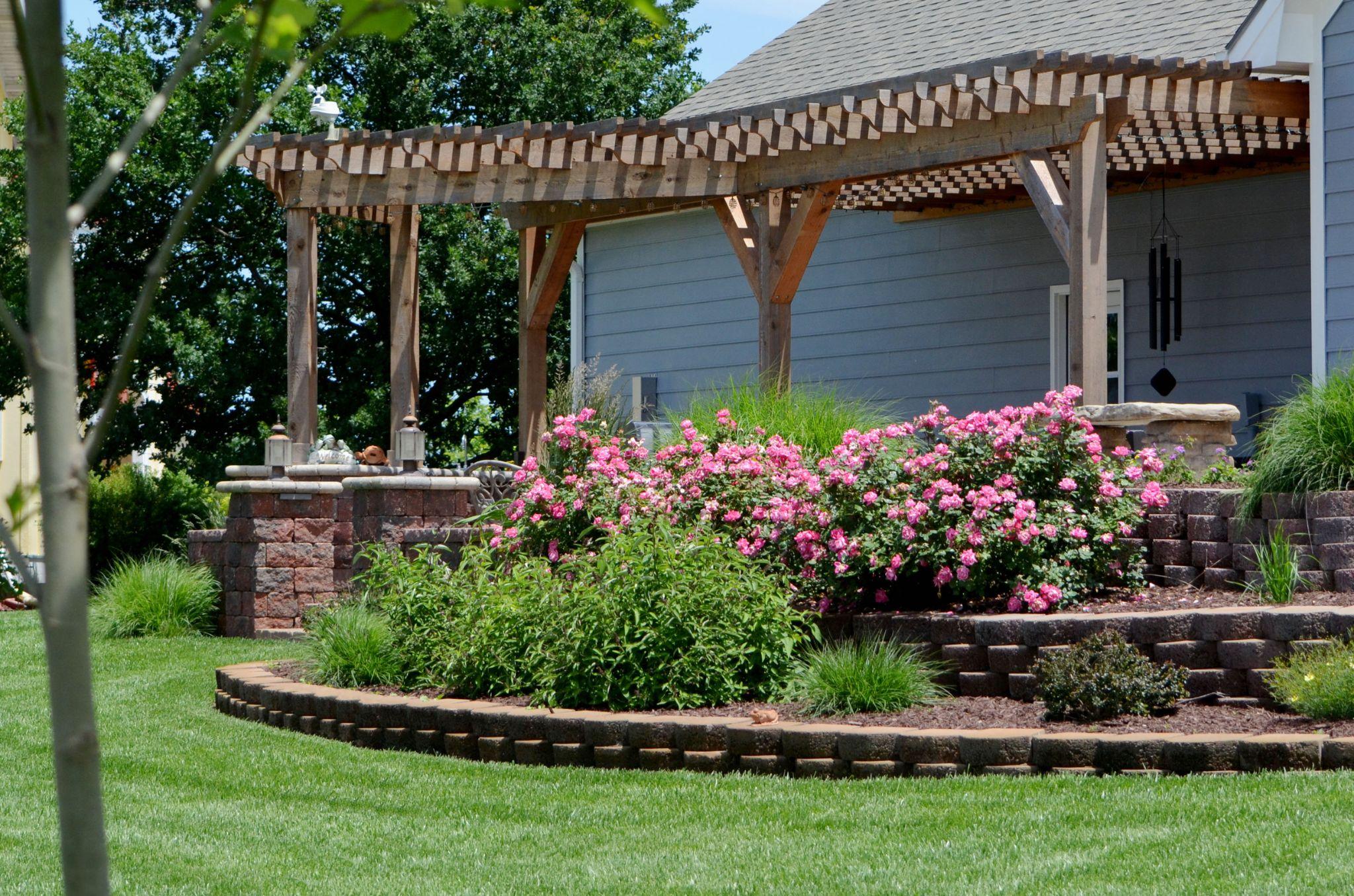 Tiered backyard garden with pergola and flowers